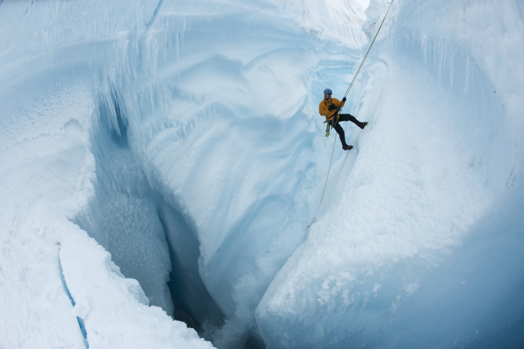 Rappeling into Survey Canyon, looking down at moulin channel dropping meltwater 2000 vertical feet into crevasses through Greenland Ice Sheet. EIS director, James Balog, is shown.